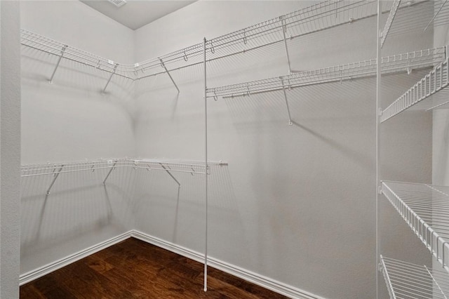 walk in closet with wood finished floors