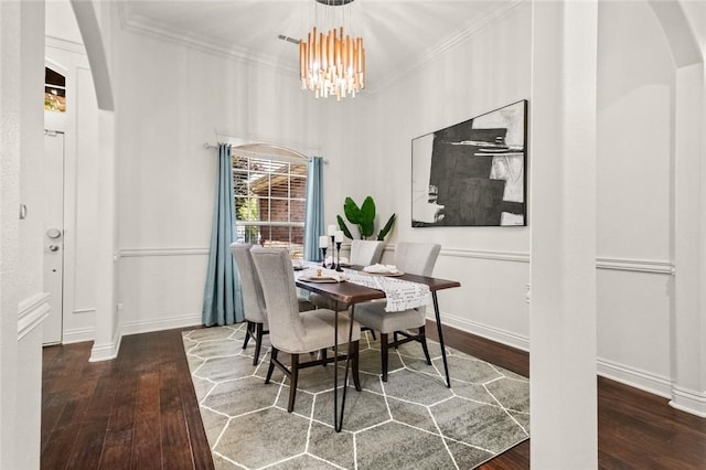 dining room with arched walkways, a chandelier, ornamental molding, and hardwood / wood-style floors