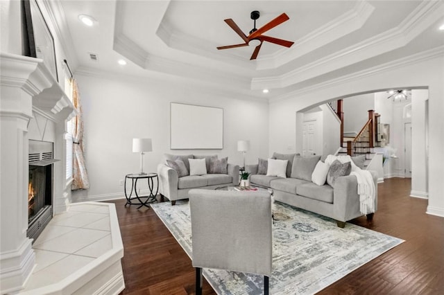 2306 SW Clover Ct, Bentonville, AR 72712 - living room featuring a ceiling fan, ornamental molding, stairs, arched walkways, and a tile fireplace
