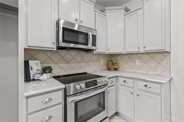 kitchen with light countertops, stainless steel appliances, and decorative backsplash