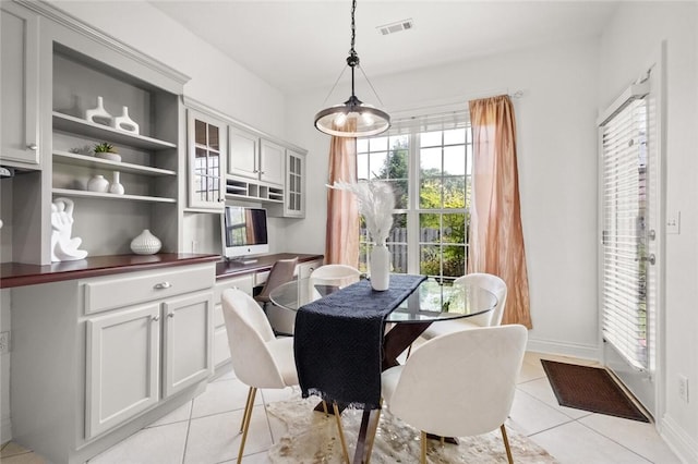 dining area featuring light tile patterned floors, a healthy amount of sunlight, baseboards, and visible vents
