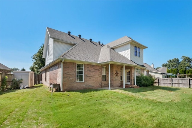 back of property featuring a storage shed, a lawn, an outbuilding, brick siding, and a fenced backyard