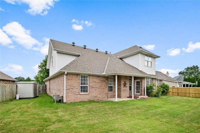 rear view of property featuring brick siding, a shed, a fenced backyard, an outbuilding, and a patio
