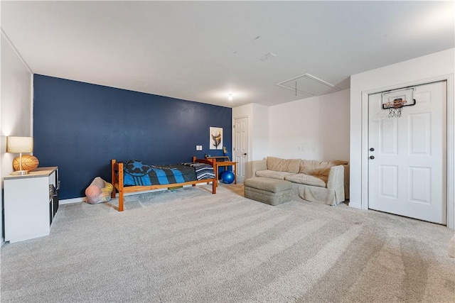 bedroom featuring carpet floors, an accent wall, baseboards, and attic access
