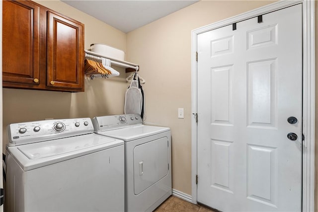 laundry area with light tile patterned floors, independent washer and dryer, and cabinet space
