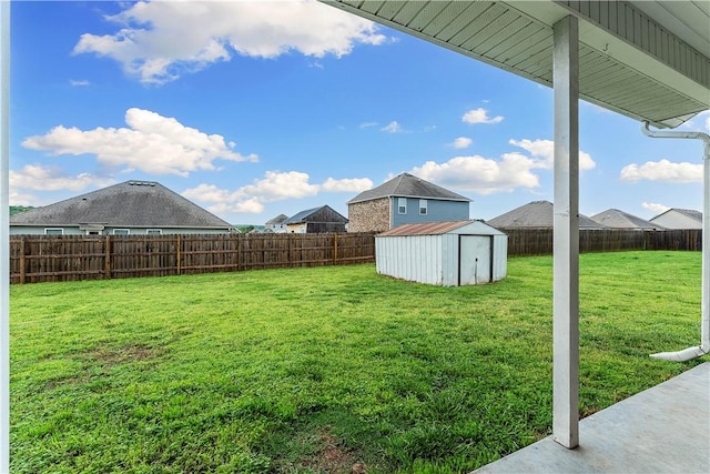 view of yard with an outdoor structure, a fenced backyard, and a storage unit