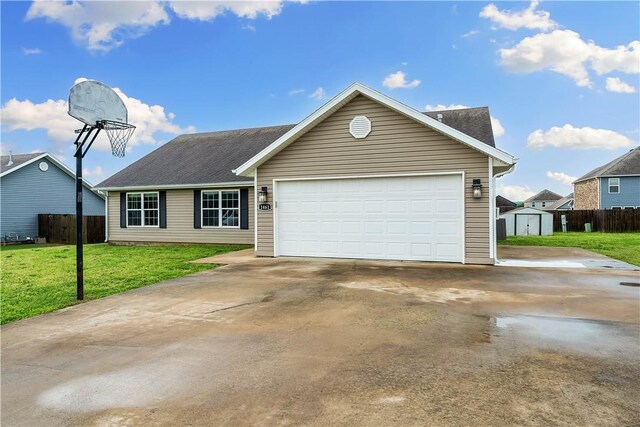 ranch-style house with a storage shed, fence, and a front lawn