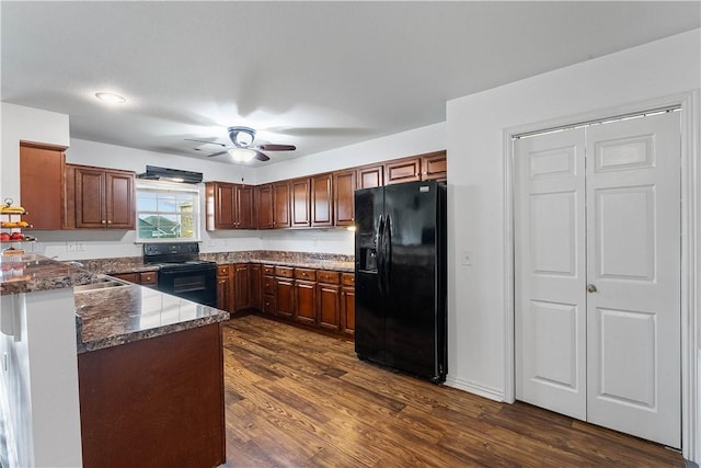 kitchen with ceiling fan, black appliances, a peninsula, dark stone countertops, and dark wood-type flooring