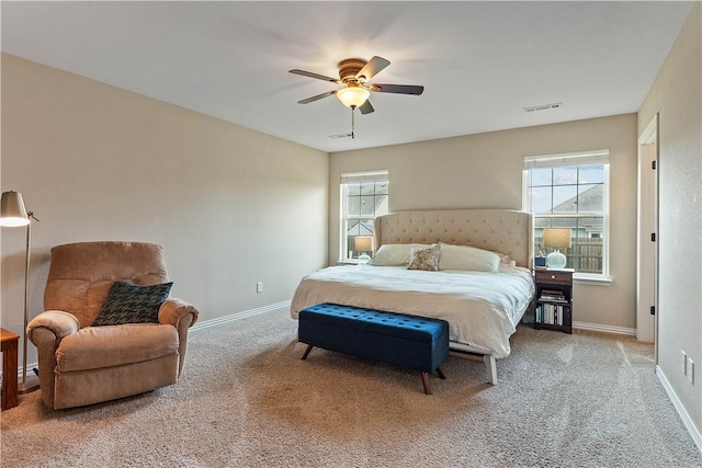 carpeted bedroom with baseboards, multiple windows, ceiling fan, and visible vents