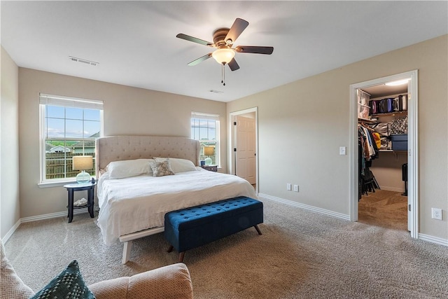 carpeted bedroom featuring visible vents, baseboards, ceiling fan, and a spacious closet