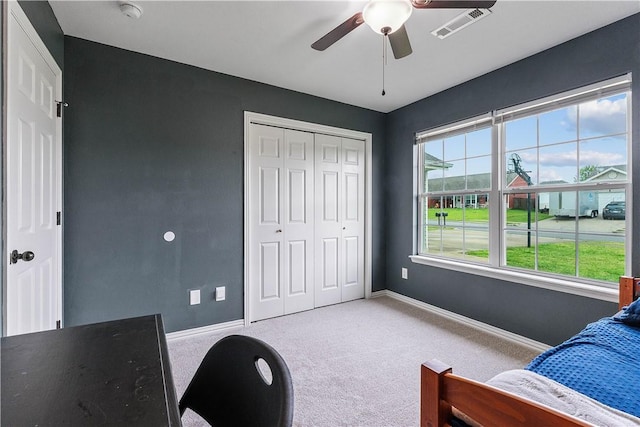 bedroom featuring a ceiling fan, visible vents, baseboards, a closet, and carpet flooring