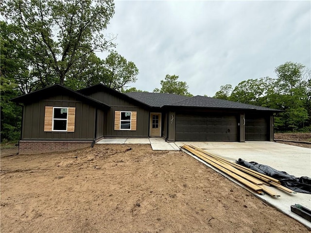 ranch-style home featuring board and batten siding, driveway, and a garage