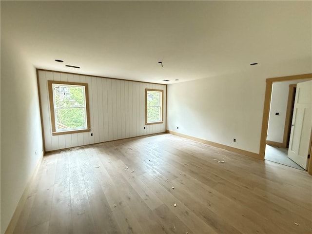 empty room with baseboards and light wood-type flooring