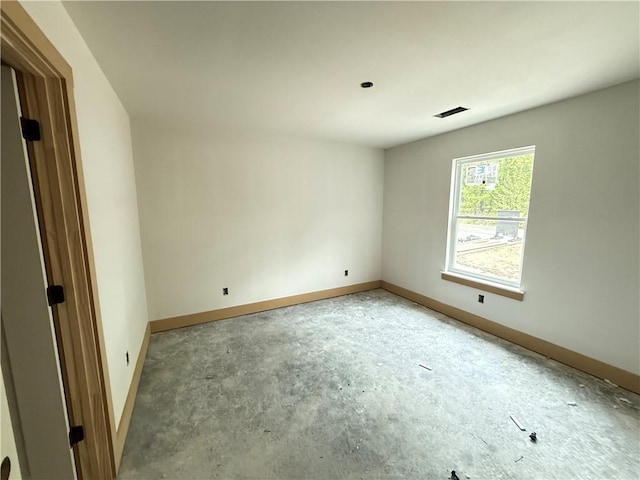 unfurnished room featuring baseboards, concrete flooring, and visible vents