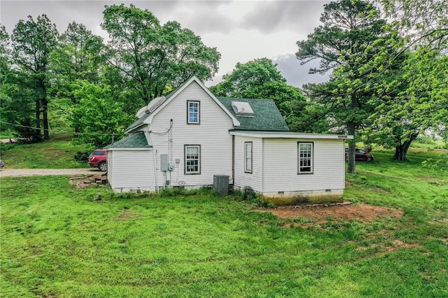 back of property featuring a yard, cooling unit, and roof with shingles