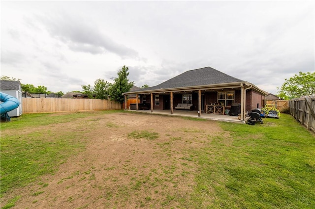 back of property featuring a patio, a fenced backyard, and a yard