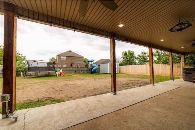 2915 N 15th Pl, Rogers, AR 72756 - view of patio / terrace with a trampoline, a playground, a storage unit, an outbuilding, and a ceiling fan