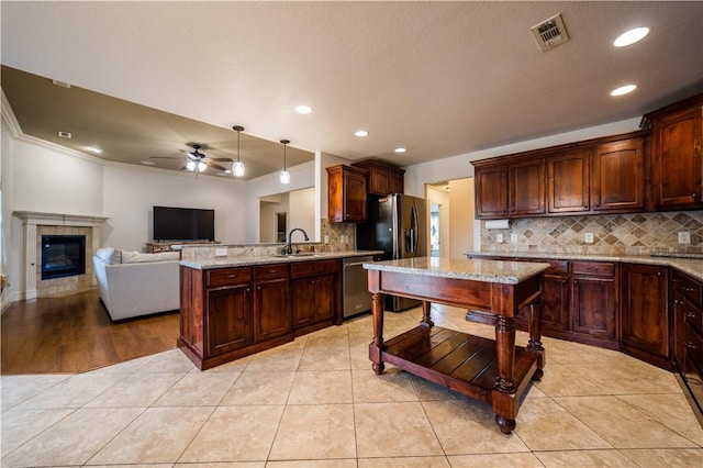 kitchen featuring visible vents, decorative backsplash, ceiling fan, a sink, and stainless steel appliances