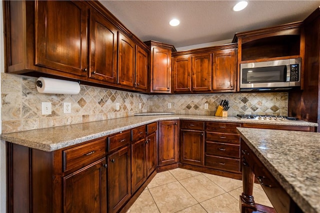 2915 N 15th Pl, Rogers, AR 72756 - kitchen with appliances with stainless steel finishes, light stone countertops, light tile patterned floors, decorative backsplash, and recessed lighting
