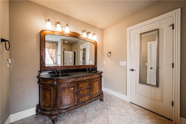 full bathroom featuring baseboards, a sink, tile patterned flooring, and double vanity