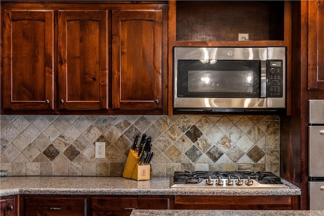 kitchen featuring light countertops, appliances with stainless steel finishes, and decorative backsplash