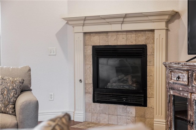interior details featuring a tile fireplace
