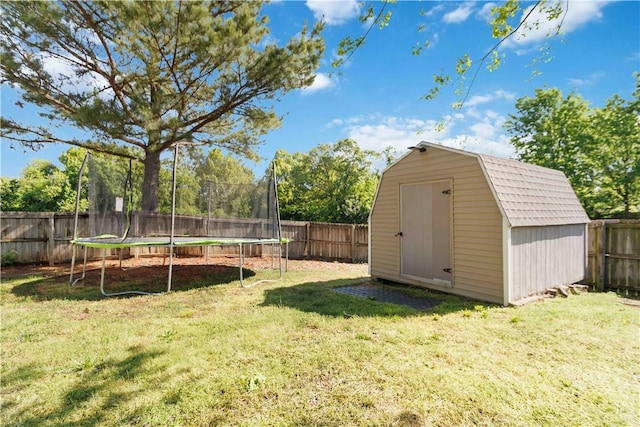 view of yard with a fenced backyard, a storage unit, a trampoline, and an outdoor structure