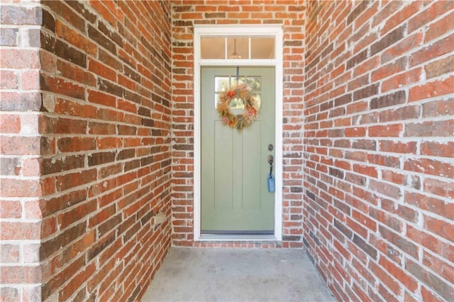 view of exterior entry with brick siding