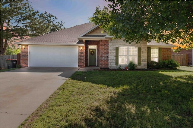 ranch-style house featuring fence, an attached garage, driveway, and a front lawn