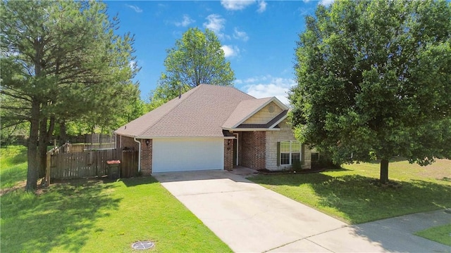 view of front facade featuring a garage, fence, a front yard, brick siding, and driveway