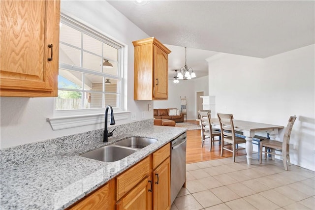 kitchen with light stone countertops, a notable chandelier, a sink, dishwasher, and light tile patterned floors