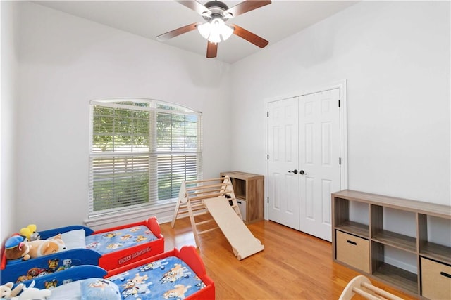 bedroom with a closet, a ceiling fan, and light wood-style flooring
