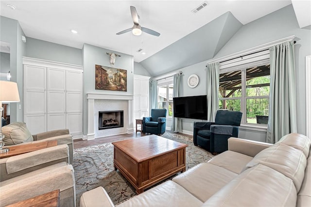 living room featuring ceiling fan, visible vents, a wealth of natural light, and vaulted ceiling