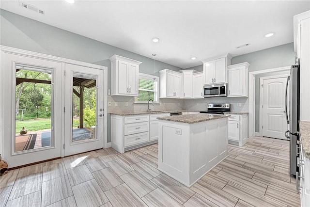 kitchen featuring a sink, appliances with stainless steel finishes, and white cabinets