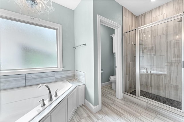 full bath with a garden tub, a shower stall, baseboards, toilet, and a chandelier