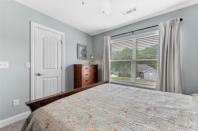 carpeted bedroom featuring a ceiling fan, baseboards, and visible vents