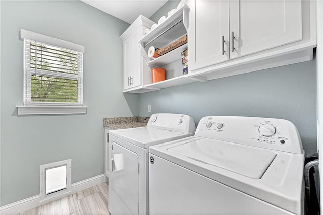 laundry area featuring baseboards, cabinet space, and washing machine and clothes dryer