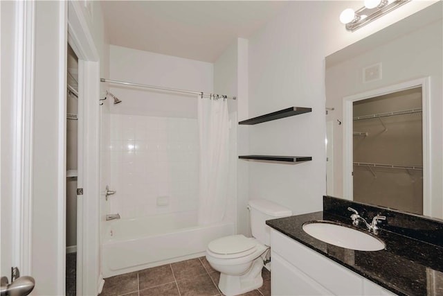 full bathroom featuring toilet, a spacious closet, tile patterned flooring, and vanity