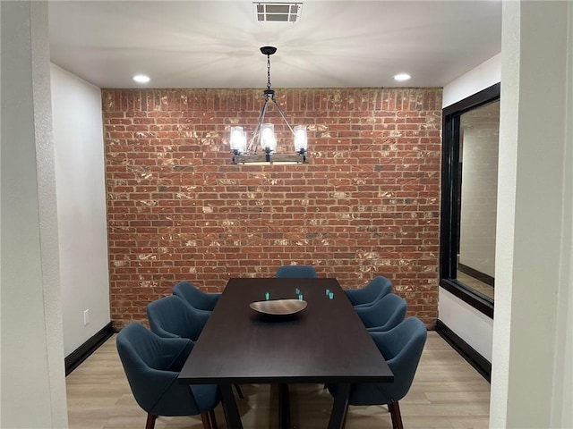 4261 Meadow Creek Cir Unit 204, Fayetteville, AR 72703 - dining room featuring baseboards, brick wall, an inviting chandelier, visible vents, and light wood-style floors