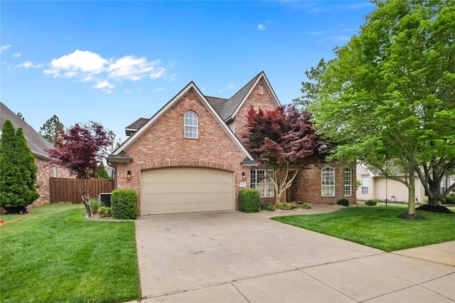 view of front facade featuring fence, a front lawn, brick siding, a garage, and concrete driveway