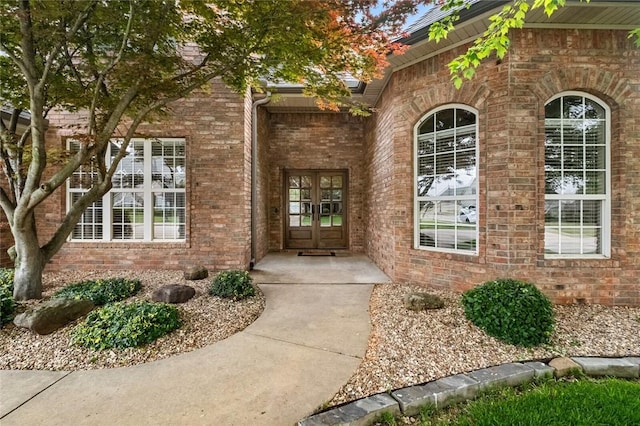 doorway to property featuring french doors and brick siding