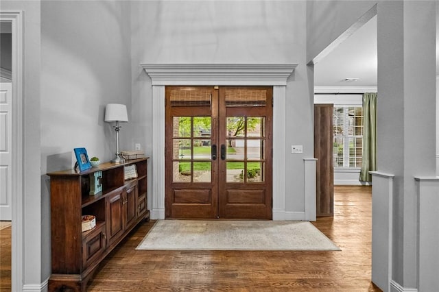 entrance foyer featuring french doors, plenty of natural light, wood finished floors, and a high ceiling