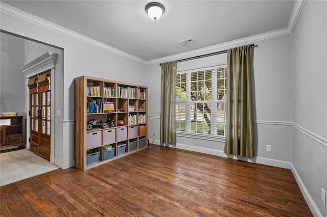 living area with baseboards, visible vents, ornamental molding, and wood finished floors