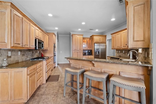 kitchen featuring crown molding, appliances with stainless steel finishes, a sink, a peninsula, and visible vents