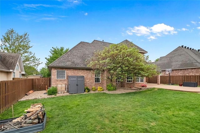 rear view of house featuring a fenced backyard, a patio, a lawn, and brick siding