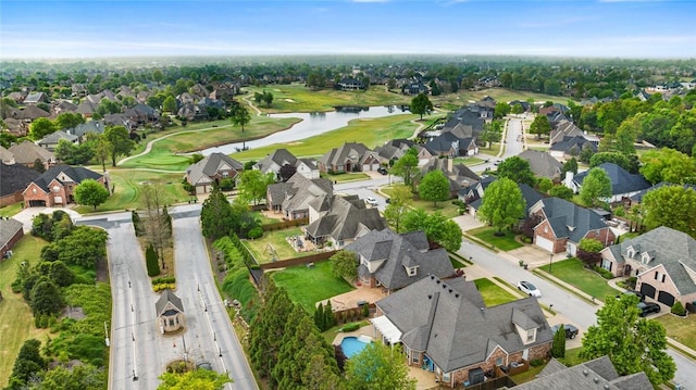 drone / aerial view featuring a water view, view of golf course, and a residential view
