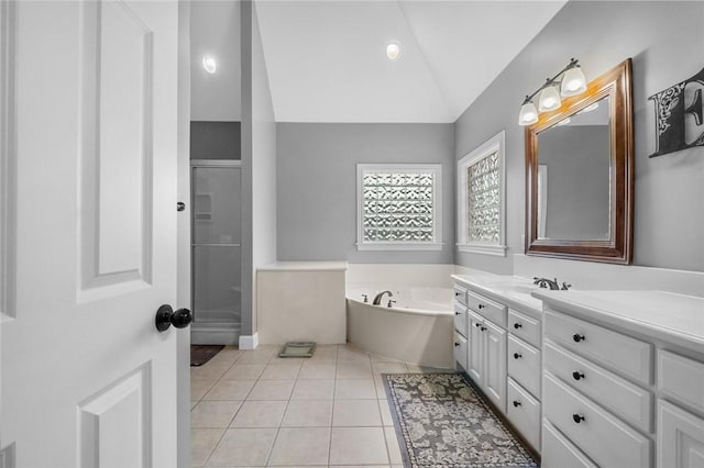 bathroom featuring tile patterned flooring, vanity, lofted ceiling, a garden tub, and a stall shower