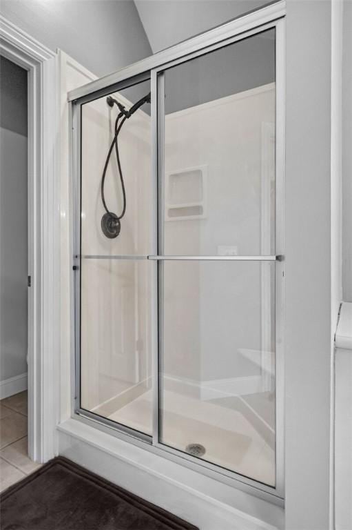 bathroom with tile patterned floors and a shower stall