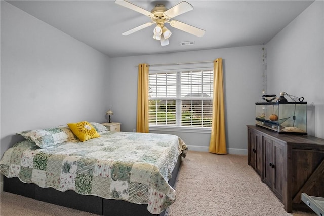 bedroom featuring baseboards, a ceiling fan, visible vents, and light carpet