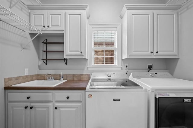 laundry room featuring cabinet space, separate washer and dryer, and a sink
